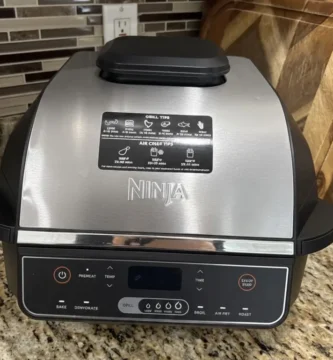 A sleek silver and black Ninja Foodi Smart XL 6-in-1 Indoor Grill sitting on a granite countertop, reviewed by Tool Tested.