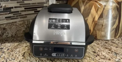 A sleek silver and black Ninja Foodi Smart XL 6-in-1 Indoor Grill sitting on a granite countertop, reviewed by Tool Tested.