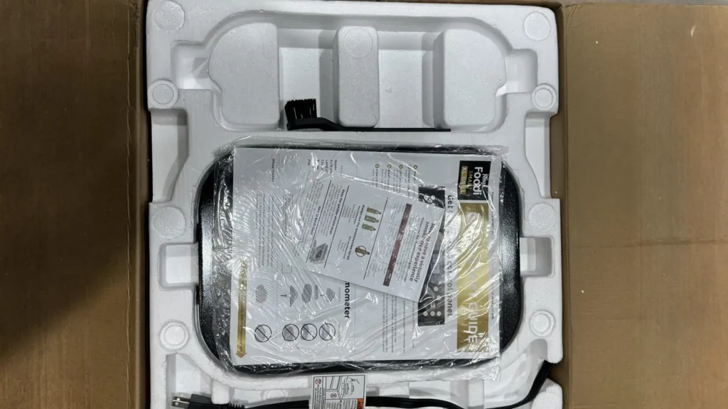 Top-down view of the Ninja Foodi grill inside its original cardboard packaging with foam inserts.