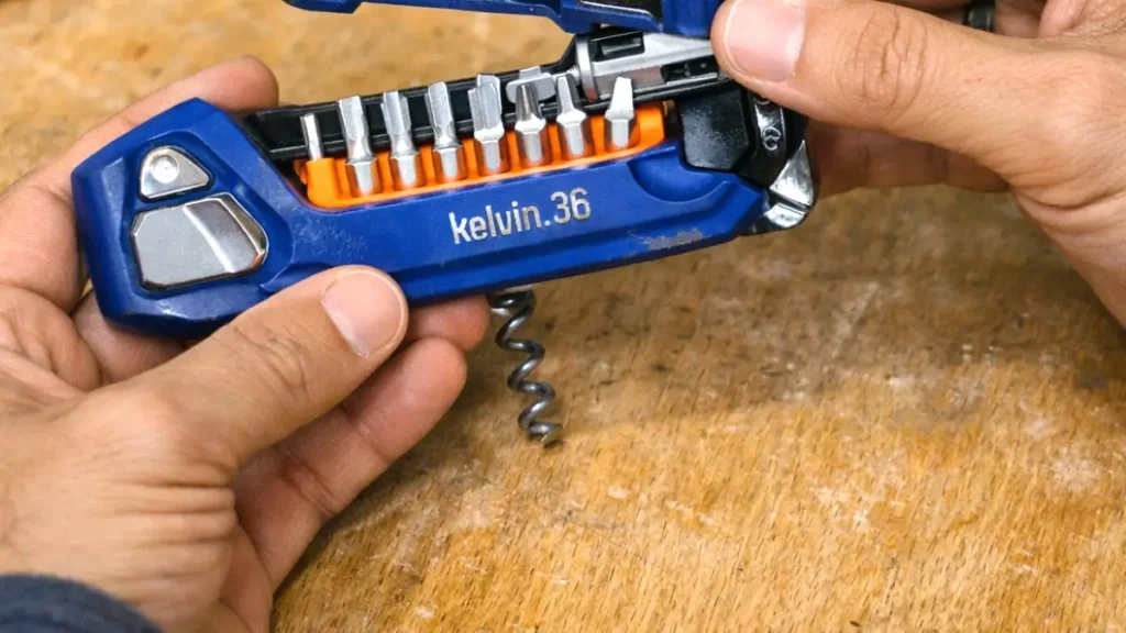 Close-up of a multi‑tool showing internal bit storage and metal construction.