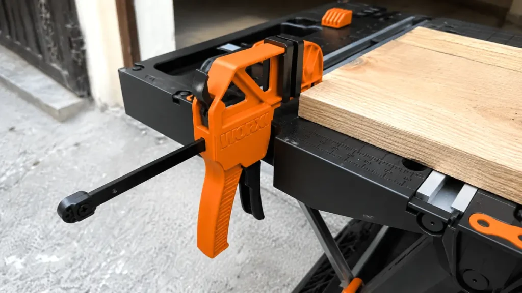 Close up of proprietary bar clamp holding wood on a work table
